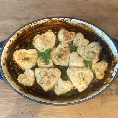 Hearty beef stew with heart-shaped cheese scones on top