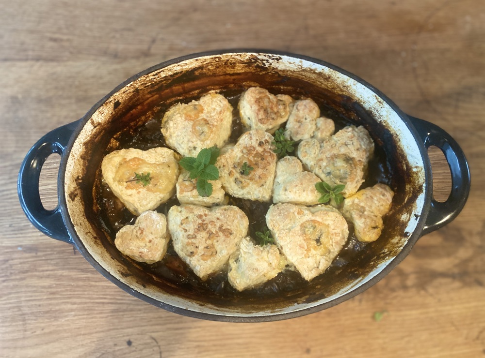 Hearty beef stew with heart-shaped cheese scones on top